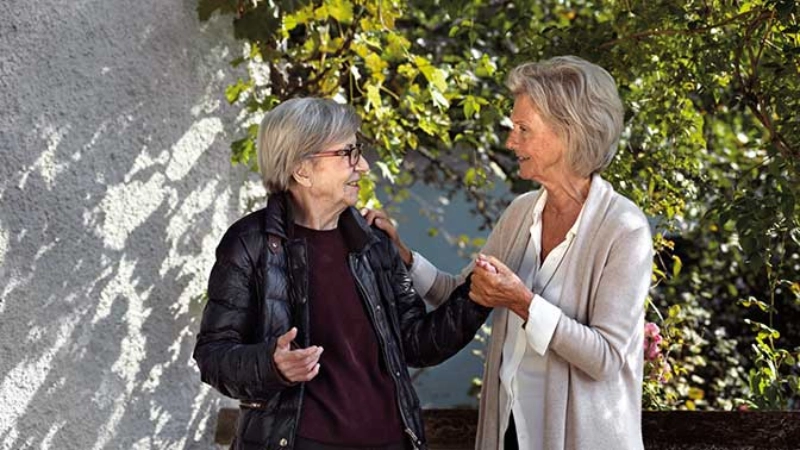 Deux femmes discutent et se tiennent par la main.