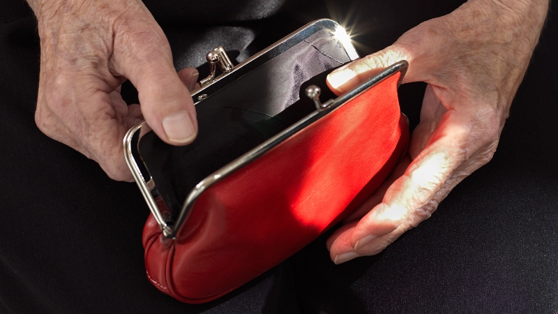 Deux mains ouvrant un portefeuille rouge vide
