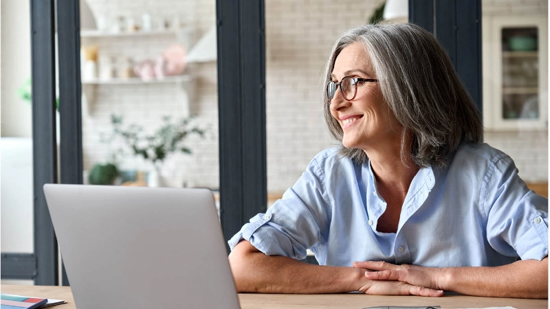 Quatre seniors sur un canapé avec des appareils numériques