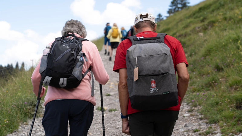 Deux personnes marchent sur un sentier en pleine nature, dos à l’appareil photo.