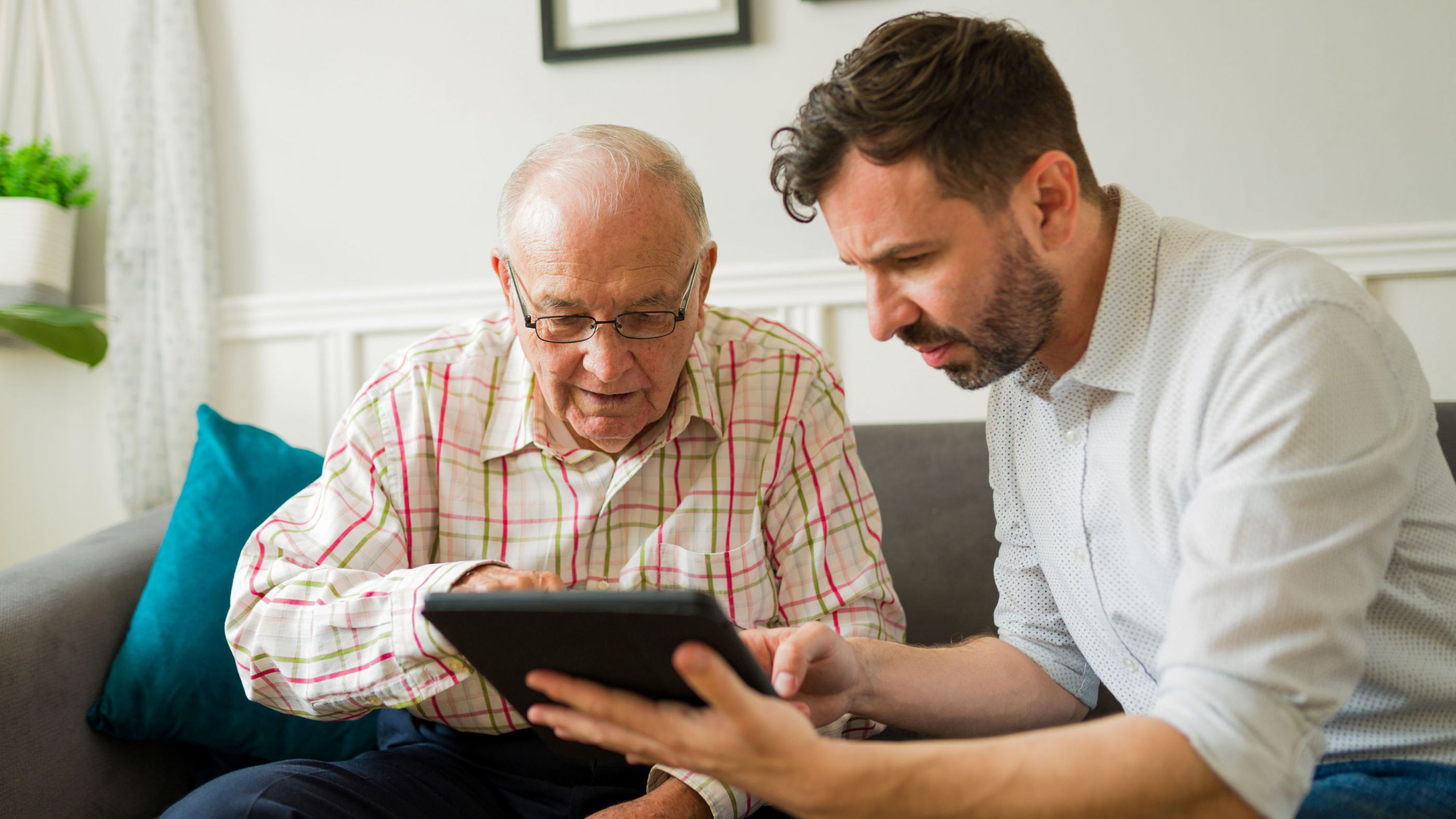 Un bénévole explique quelque chose à une personne âgée sur une tablette